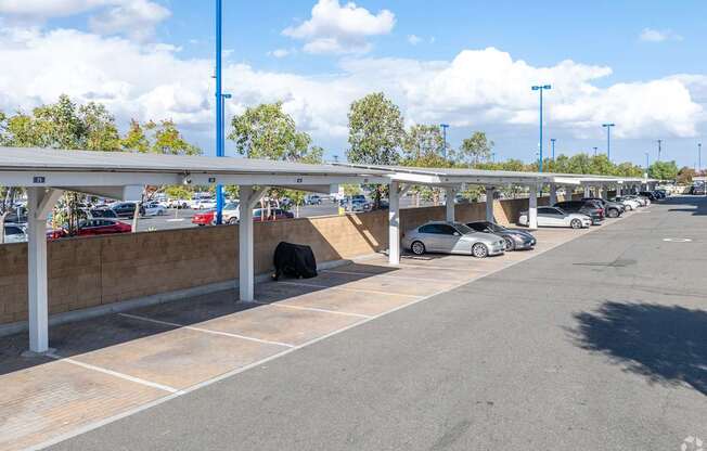 A parking lot with cars parked under a canopy.