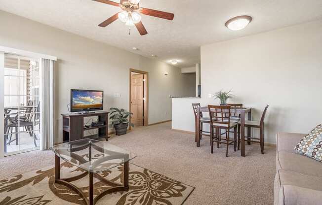Villa living room with ceiling fan and walkout patio at Stone Ridge apartments in south Lincoln NE