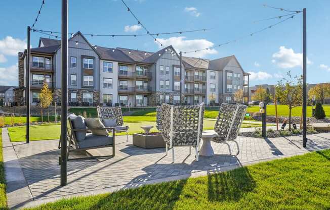 a patio with chairs and a table in front of an apartment building