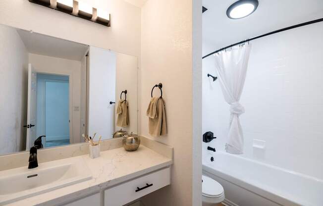 A bathroom with a white sink and a white bathtub.