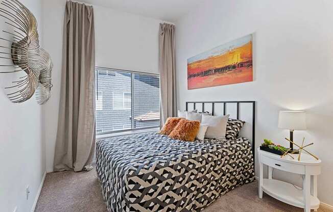 A bedroom with a large bed and a painting on the wall.