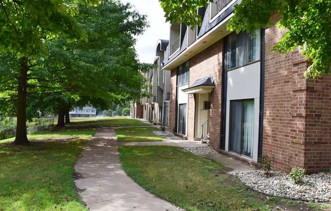 a sidewalk in front of a brick apartment building at Seville Apartments, Michigan