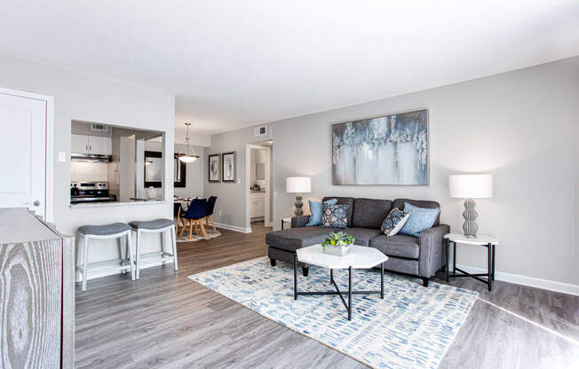 a living room with a grey couch and a white coffee table on a blue and white rug  at Barcelo at East Cobb, Marietta, GA