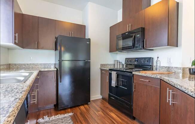 A kitchen with a black refrigerator and black oven at Riverplace Apartment Homes, Independence, OR
