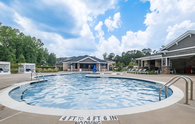 a large pool with a house in the background