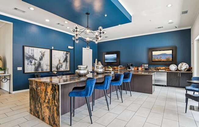 A kitchen with a blue accent wall and a marble island.