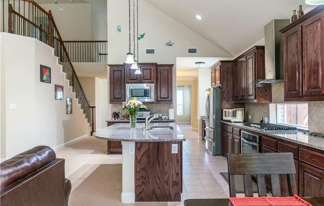 Grand entry, Open floor plan with high ceiling, Spacious rooms, Elegant kitchen featuring stainless steel appliances.