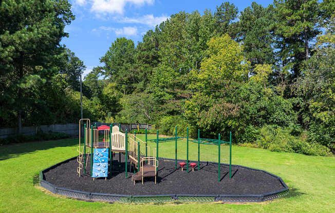 a playground in the middle of a park with trees
