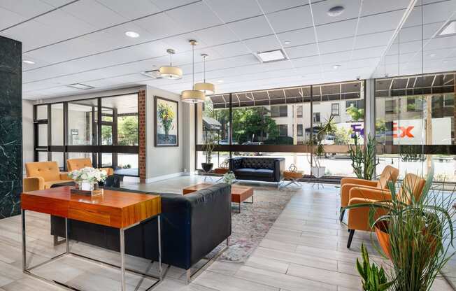 the lobby of a hotel with chairs and a table