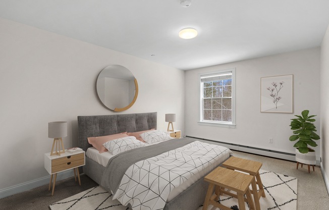 a bedroom with white walls and a gray bed