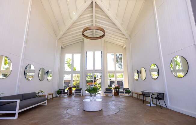 a living room with a vaulted ceiling and large windows at Campbell West Apartments, Campbell