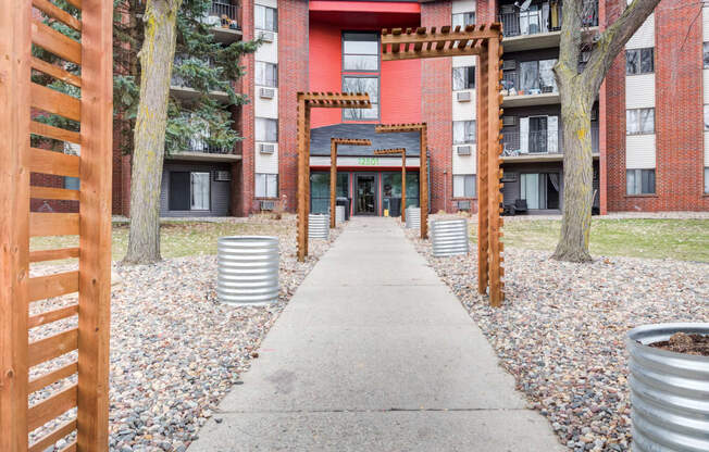 a walkway with a red brick building in the background