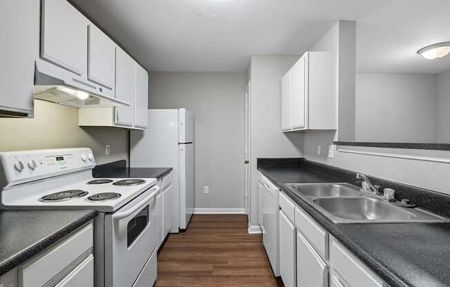 A kitchen with white appliances and cabinets.