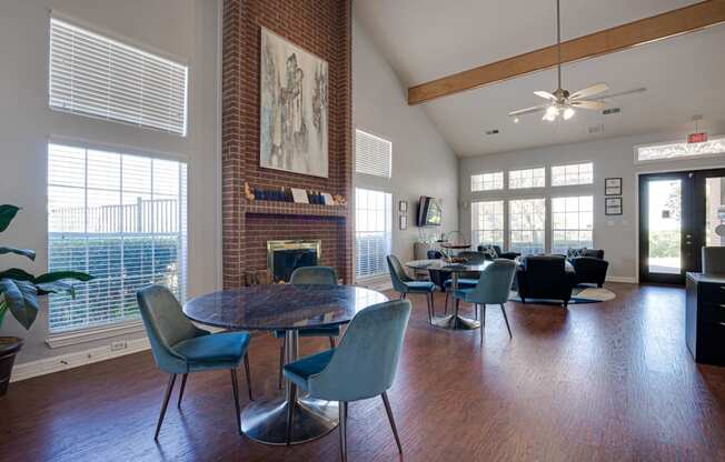 a living room with a table and chairs and a brick fireplace