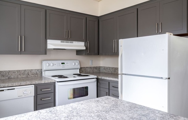 a kitchen with gray cabinets and white appliances