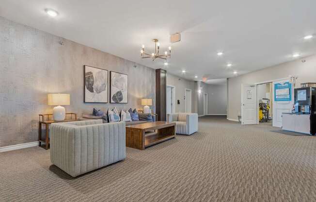 A well-lit waiting room with a grey sofa and a wooden coffee table.
