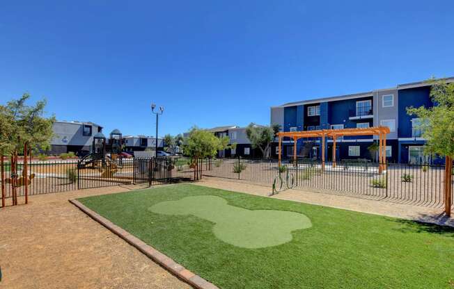 a playground with a green field in front of some apartments