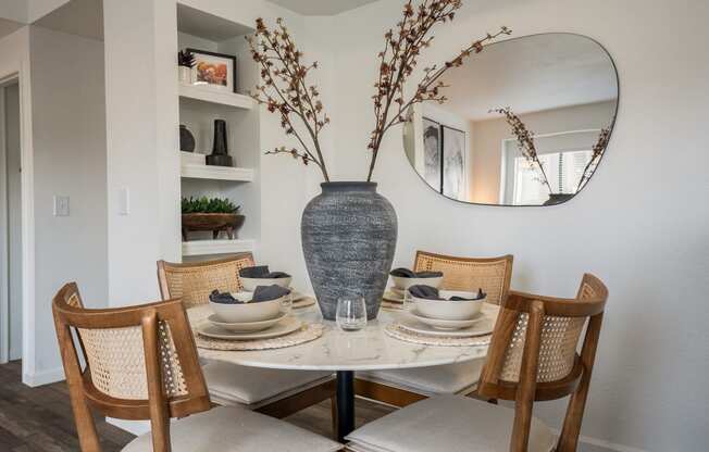 a dining room with a table and chairs and a vase