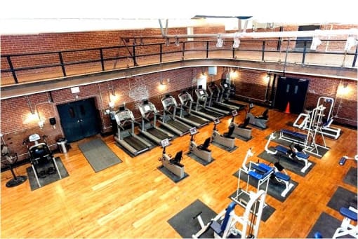 a gym with a bunch of exercise equipment on a wooden floor