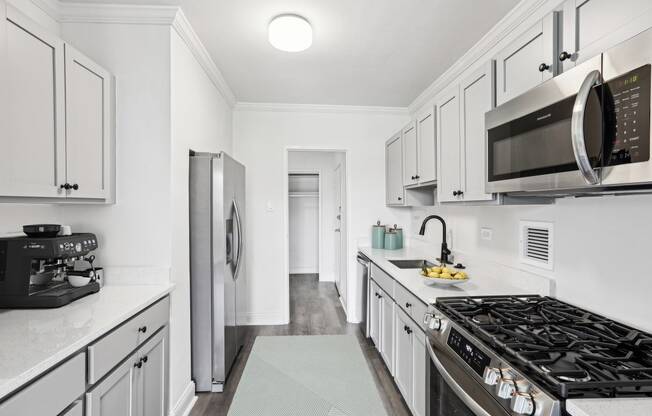 a white kitchen with stainless steel appliances and white cabinets