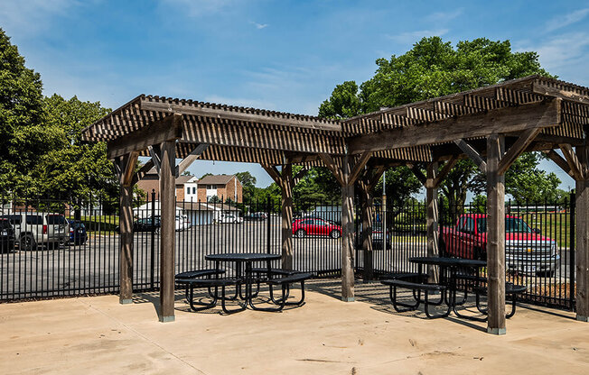 a picnic shelter with tables and chairs in a park