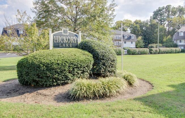 the sign for hickory lake at the entrance to the park on the grass