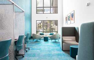 A room with blue carpet and white chairs.