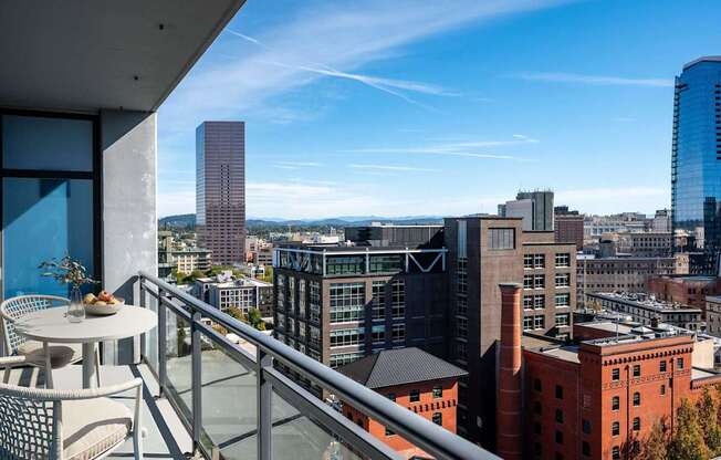 a balcony with a view of the city and a table and chairs