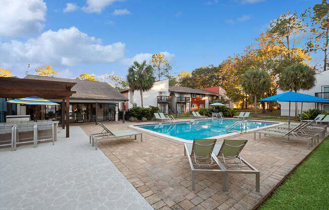 Community Swimming Pool with Pool Furniture at Heron Walk Apartments in Jacksonville, FL.