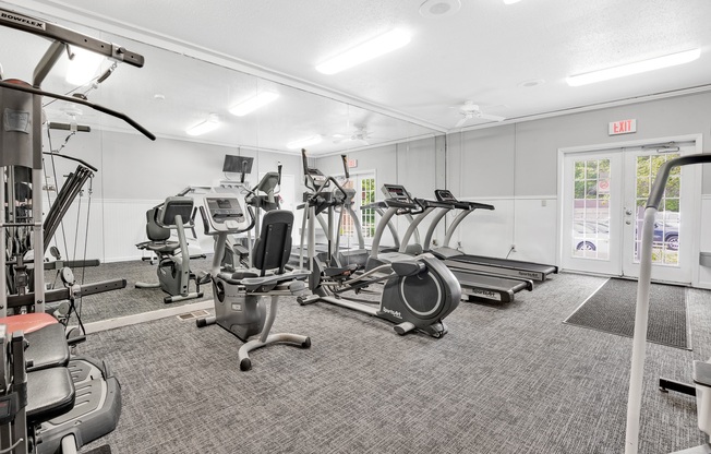 A gym with treadmills, elliptical machines, and other exercise equipment.
