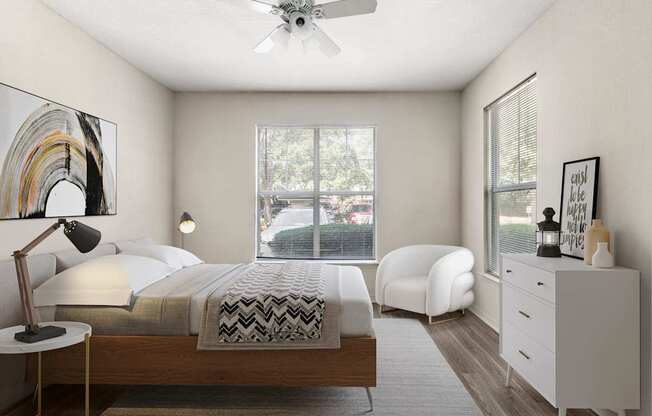 A bedroom with a bed, chair, and a ceiling fan.