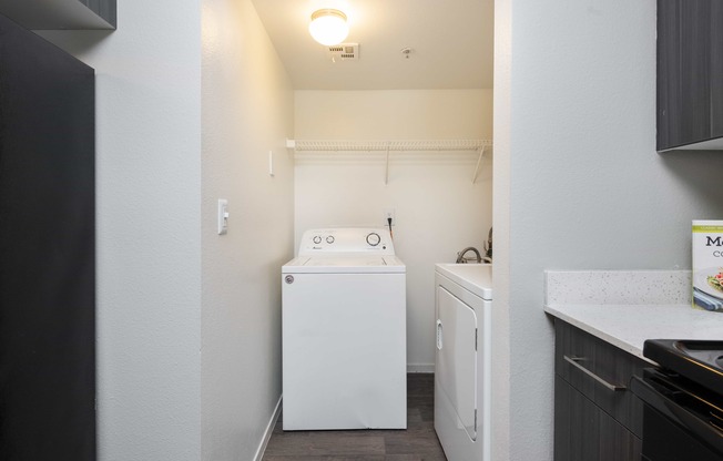 a small laundry room with a washer and dryer and a white washer