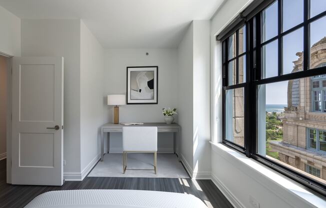 a bedroom with a bed and a desk and large windows  at The Belden Stratford, Chicago, 60614