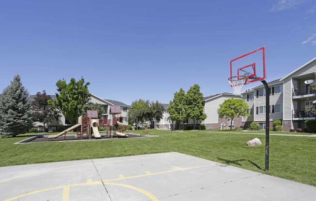 Half basketball court next to playground and large grass area