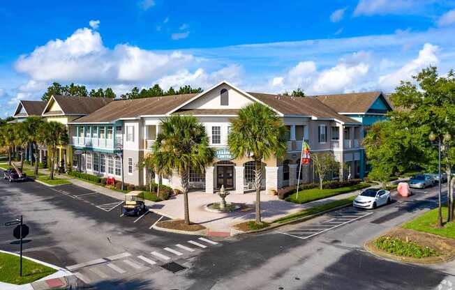 A sunny day at a residential complex with cars parked and driving.