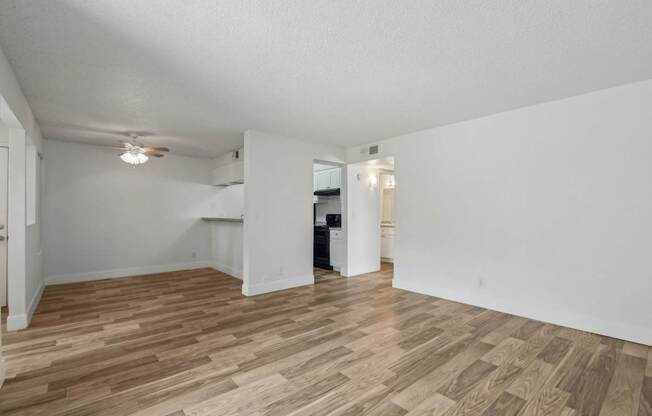 A room with wooden flooring and white walls.