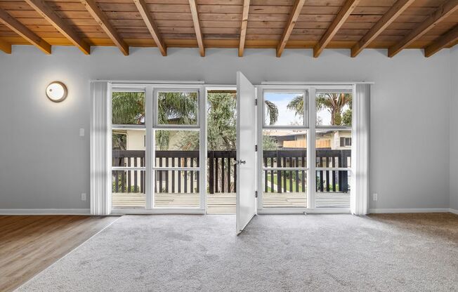 an empty living room with sliding glass doors to a balcony