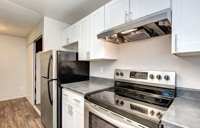 a kitchen with stainless steel appliances and white cabinets