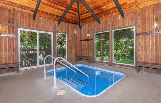 a resort style swimming pool with a wooden ceiling and concrete flooring at Lincoln Village Apartments, Spokane, WA