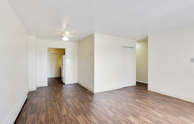 Bright apartment with sleek wooden floors and an inviting open layout leading to a kitchen area.