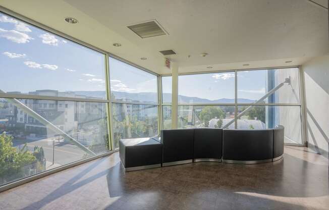 the lobby of a building with large windows and a black couch