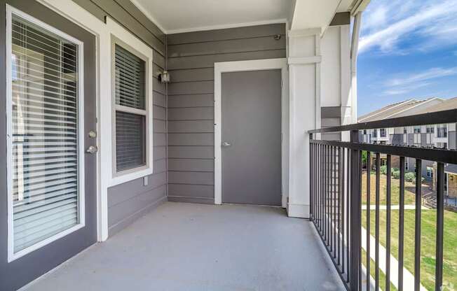 A grey door is on the left and a black railing is on the right.