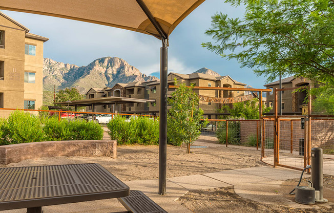 a picnic table in a courtyard with buildings and mountains in the background
