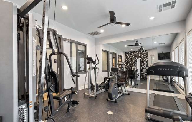 a gym with weights and cardio equipment in a home for sale