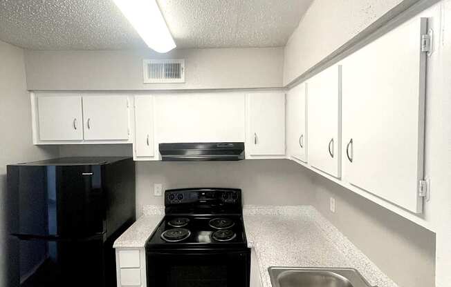 an empty kitchen with a sink and a stove at Cambridge Village Apartments, Houston ? 