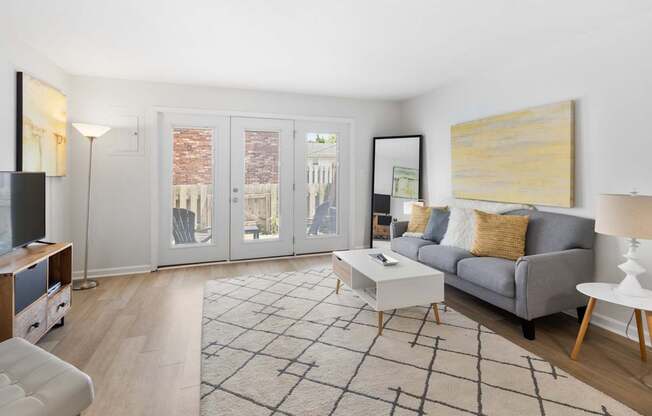 Modern living room at Monon Living in Broad Ripple featuring sleek furnishings, bright natural light, and direct access to a private patio near the Monon Trail.