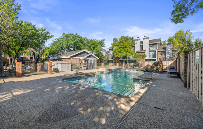 A residential area with a pool surrounded by houses and trees.