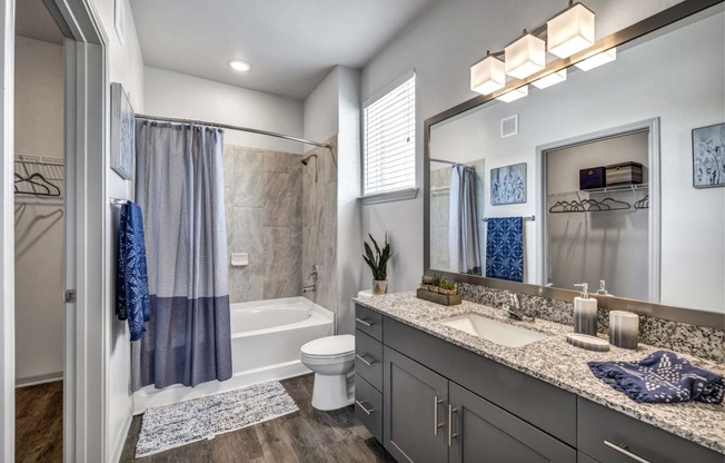 a bathroom with a shower and a toilet and a sink