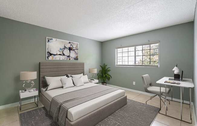 A bedroom with a large bed, a desk, and a chair.