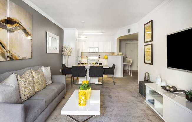 A modern living room with a grey sofa and a white coffee table.